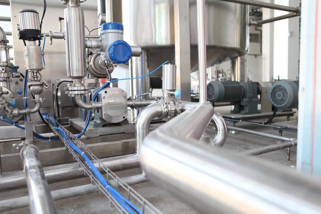 Tubulação de aço inox com instrumentos e bombas em planta de processo